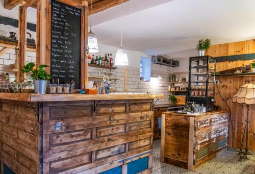 a restaurant with a bar with a chalkboard on the wall at Minifaktúra Loft Apartman & Reggeliző és Ételbár in Szokolya