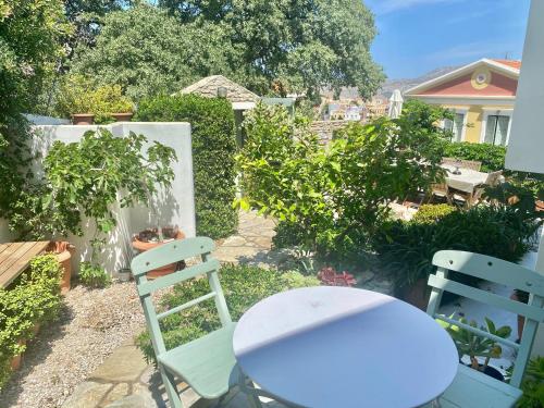 a white table and two chairs in a garden at Panorama in Symi