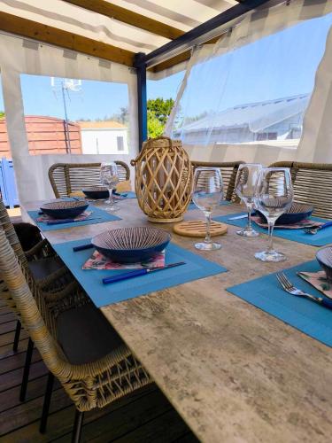 a table with chairs and wine glasses on a boat at Mobilhome Metanova in Camiers