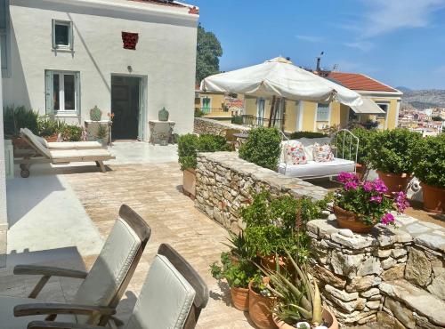 a patio with chairs and a stone wall at Panorama in Symi