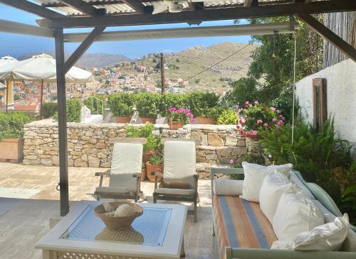 a patio with a couch and a table and chairs at Panorama in Symi