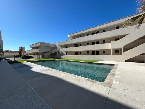 une piscine devant un immeuble dans l'établissement NAÏA ALO, à Sérignan