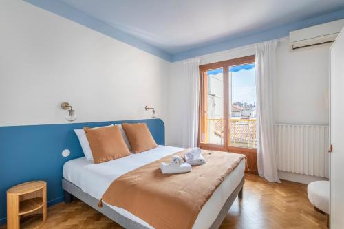 une chambre avec un lit et une grande fenêtre dans l'établissement L'Olympe - Bel appt climatisé dans Marseille, à Marseille