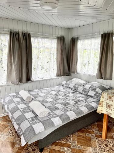 a large bed in a room with windows at Domek Holenderski in Mielno