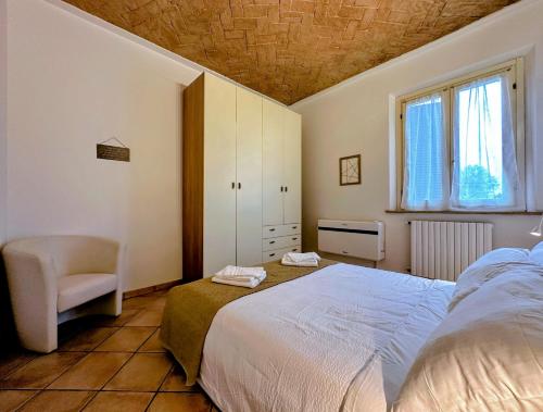 a bedroom with a bed and a chair and a window at Vicino al Centro e a Parcheggi Gratuiti - Affresco Strepitoso in Modena