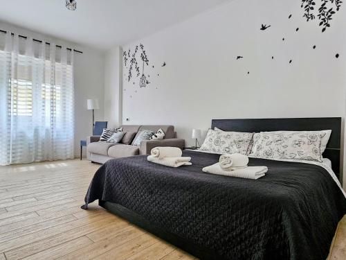 Un dormitorio con una cama grande y un sofá. en Maremè Guest House Ostia, en Lido di Ostia