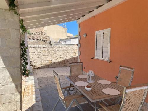 a wooden table and chairs on a patio at Lovely Independent Villa in Plaia Grande