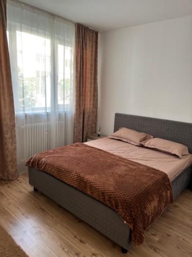 Un dormitorio con una cama y una ventana grande. en EMC Apartament ultracentral, en Craiova