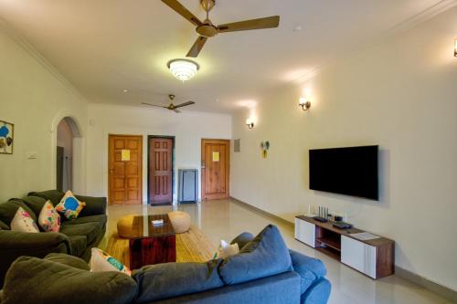 a living room with a couch and a tv at Coastal Bliss By Masaka in Anjuna