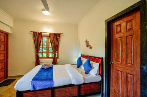 a bedroom with a bed and a window and a door at Coastal Bliss By Masaka in Anjuna