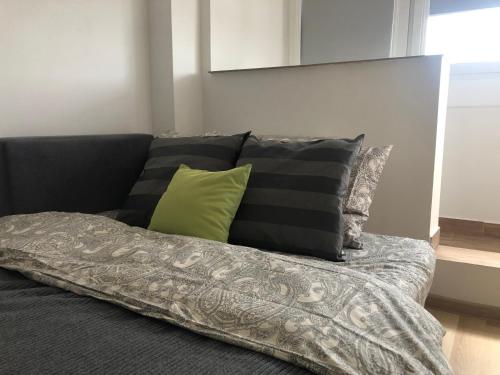 Un sofá con almohadas y una manta. en Inżynierska - Madera rooms, en Wroclaw