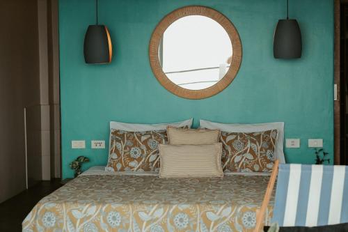 a bedroom with a bed with a mirror and pillows at Balay Kalachuchi in Barili