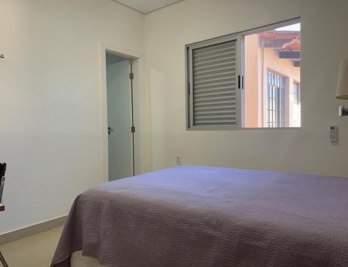 una camera da letto bianca con un letto e una finestra di SuaCasaLongeDeCasa LagoadaPrata a Lagoa da Prata