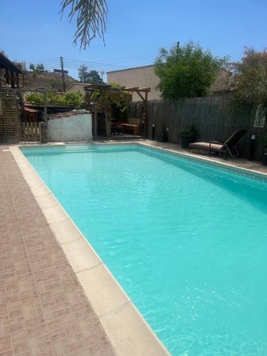 a swimming pool with blue water in a yard at Traditional Cypriot House - Akapanou in Akapnou