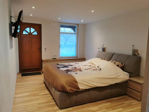 a bedroom with a large bed and a large window at Ranch du pont urgin in Planrupt