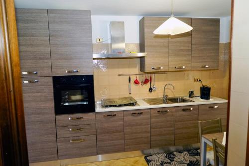 a kitchen with wooden cabinets and a sink at A casa di Dany in Palidoro