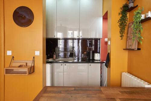 - une cuisine avec des murs jaunes et un réfrigérateur blanc dans l'établissement Lovely flat Marais - Orange, à Paris