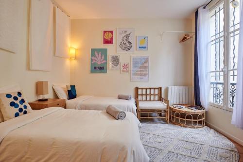 une chambre avec deux lits et une fenêtre dans l'établissement Lovely flat Marais - Orange, à Paris