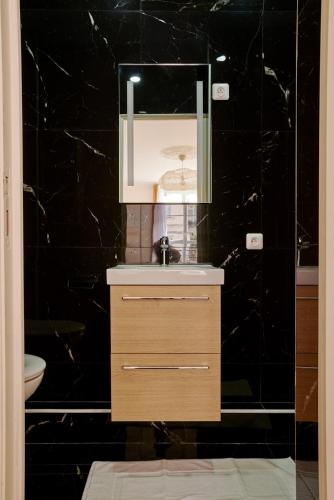 une salle de bain avec un lavabo et un miroir dans l'établissement Lovely flat Marais - Orange, à Paris