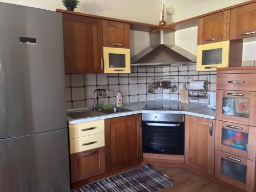 a kitchen with wooden cabinets and a stove top oven at Cozy Apartment in Ptolemaida in Ptolemaida
