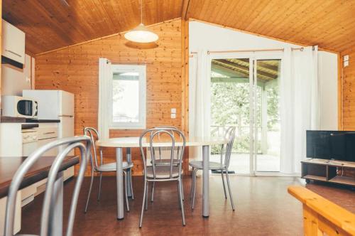 une cuisine et une salle à manger avec une table et des chaises dans l'établissement Chalet 3 étoiles - Piscine - eebbhg, à Beynat