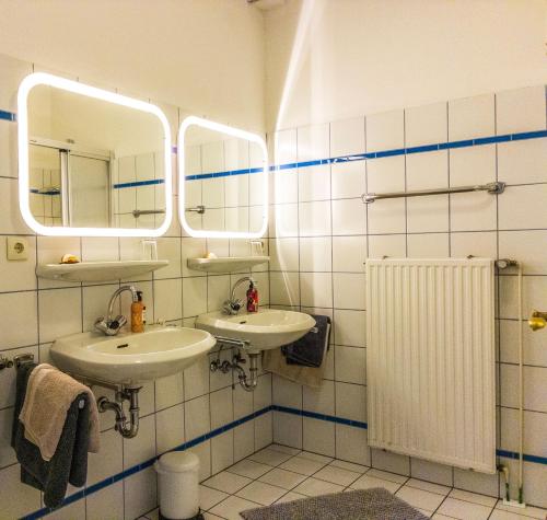 a bathroom with two sinks and two mirrors at Ferienwohnung Siel 40 Ditzum 45253 in Ditzum
