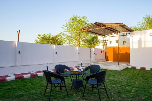a table and chairs in a yard with a patio at Alaya Stays Parvam Retreat 2-BHK Villa With Private Pool, Garden, Terrace & Aravali Hill Views in Thūr