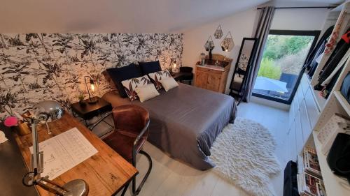 une chambre avec un lit, un bureau et une table dans l'établissement VILLA ROUQUIER, Vue Panoramique, Mer et Port de Sète, Climatisé, Jacuzzi, à Sète
