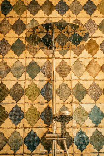 a bathroom with a tile wall with a mirror at Wayra Lodge [Kanchay] in Raposeira