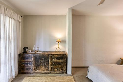 a bedroom with a dresser next to a bed at Les Hamaques Hotel in Viladamat