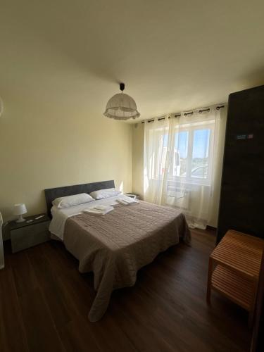 a bedroom with a bed and a large window at Casa Felice in Senigallia
