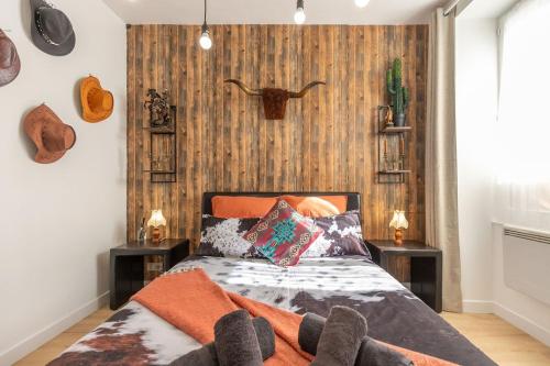 a bedroom with a bed with pillows on it at La tanière du Cowboy in Orléans