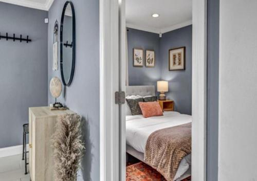 a bedroom with blue walls and a bed and a mirror at Swim and Relax In our Pool and Hot Tub and Recently Renovated in Ashtabula