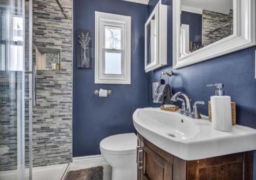 a blue bathroom with a toilet and a sink at Swim and Relax In our Pool and Hot Tub and Recently Renovated in Ashtabula