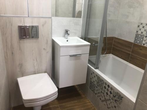 Un baño con inodoro, lavabo y bañera. en Inżynierska - Madera rooms, en Wroclaw