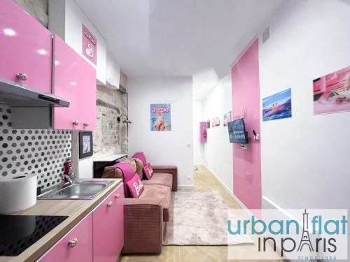 une cuisine avec des murs roses et blancs et un canapé dans l'établissement Urban Flat 193 - Barbie Paris, à Paris