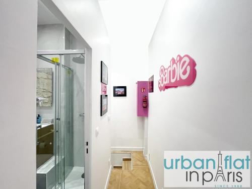 un couloir avec un panneau sur le mur dans un bâtiment dans l'établissement Urban Flat 193 - Barbie Paris, à Paris