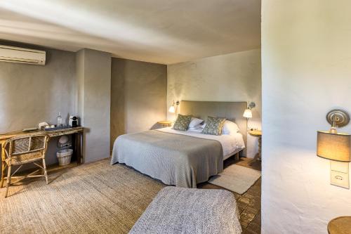 a hotel room with a bed and a desk at Les Hamaques Hotel in Viladamat