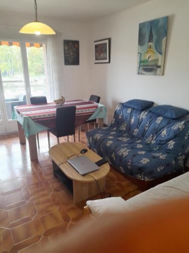 un salon avec un canapé et une table avec un ordinateur portable dans l'établissement T2 bord de mer, à Hyères
