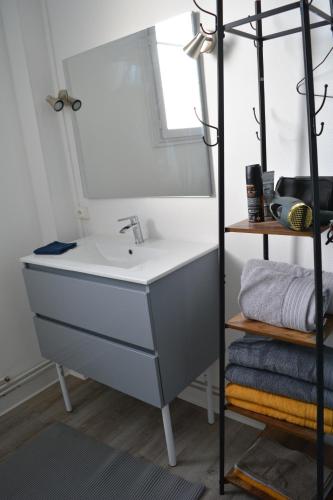 une salle de bain avec un lavabo et un miroir dans l'établissement Cyclo 2 Loire, à Saumur