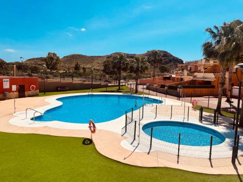 an overhead view of a large swimming pool with palm trees at La Casa del Violín in Pilar de Jaravía