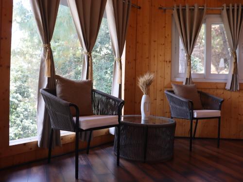 a room with chairs and a table and windows at The Woods Retreat in Lansdowne