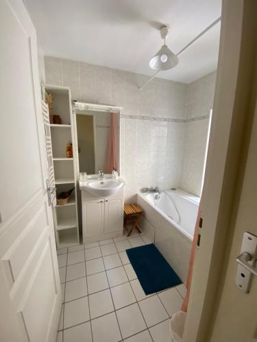 a white bathroom with a tub and a sink at Duplex 60m2 vieux centre avec balcon in Barcelonnette