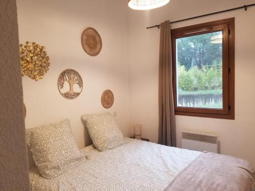 une chambre avec un lit et une fenêtre dans l'établissement Appartement cosy centre Uzès, parking gratuit, piscine, à Uzès