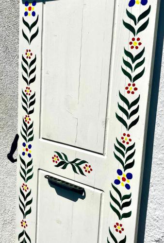 a white door with a butterfly painted on it at Cosy alpine flat with great views of Mont Blanc in Servoz