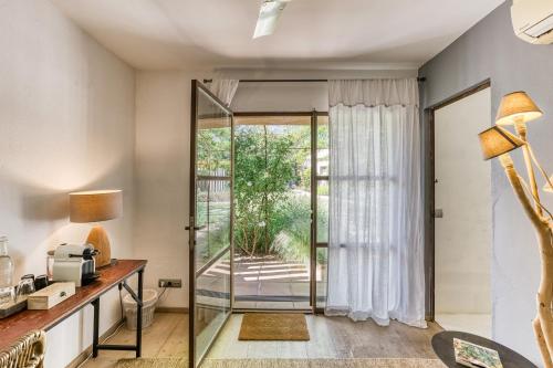 a home office with a glass door leading to a patio at Les Hamaques Hotel in Viladamat