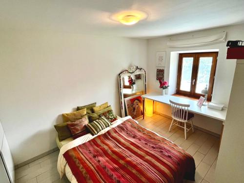 a bedroom with a bed and a desk and a window at Cosy alpine flat with great views of Mont Blanc in Servoz