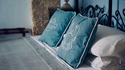 two turquoise pillows on a bed in a bedroom at Antica Dimora San Girolamo in Licata