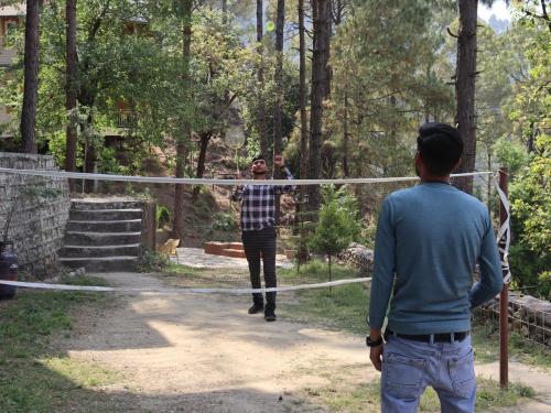 a woman walking across a net in a forest at The Woods Retreat in Lansdowne