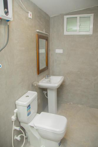 a bathroom with a white toilet and a sink at Araliya Villa Hikkaduwa in Hikkaduwa